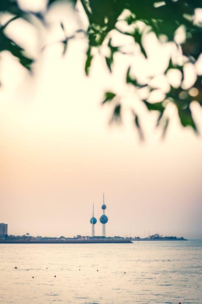 A serene view of Kuwait Towers with a sunset sky and ocean backdrop, capturing a national landmark in Kuwait City.